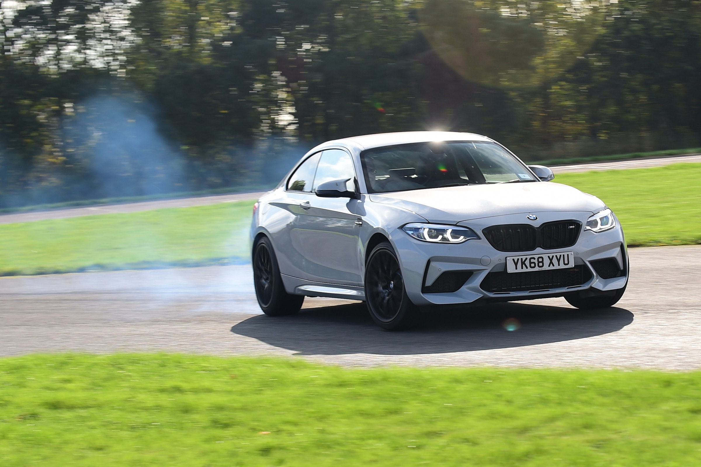 BMW M2 Competition cornering with tyre smoke