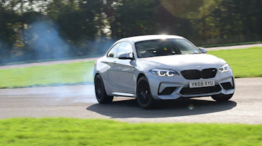 BMW M2 Competition cornering with tyre smoke