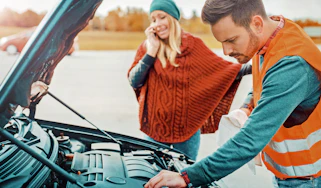 Breakdown technician working on car