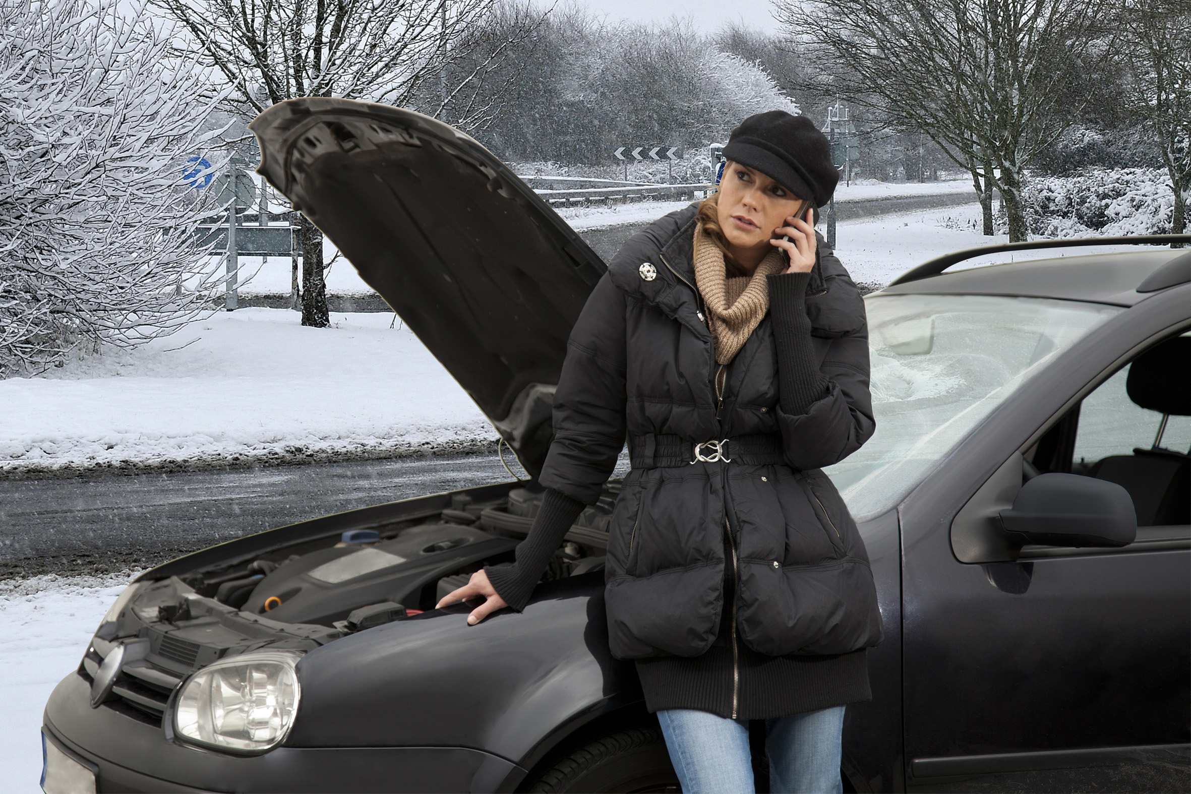 Woman on phone next to broken-down car