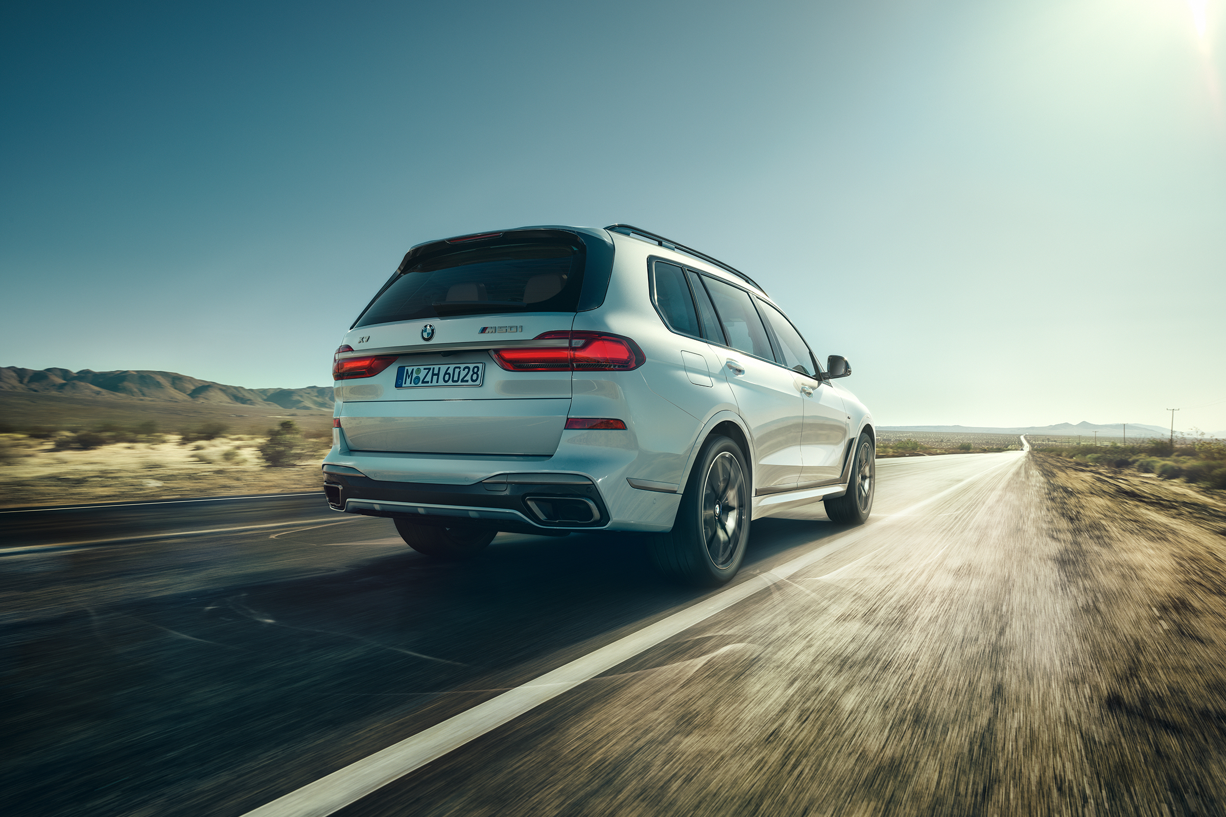 BMW X7 M50i rear view dynamic driving shot
