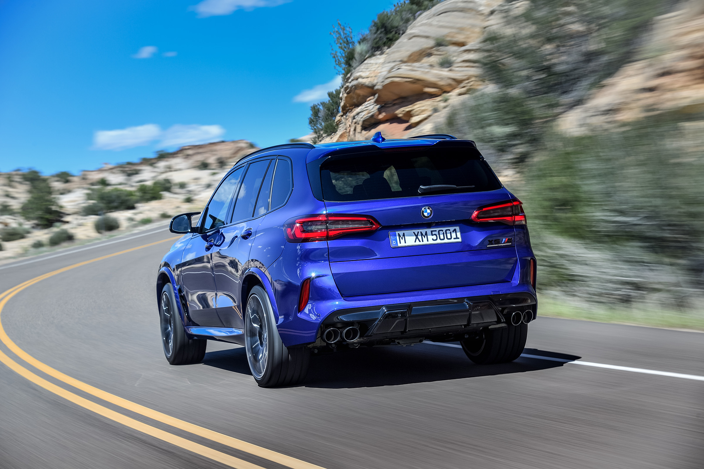 BMW X5 M Competition driving - rear left-hand-side view