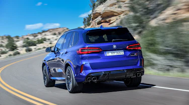 BMW X5 M Competition driving - rear left-hand-side view