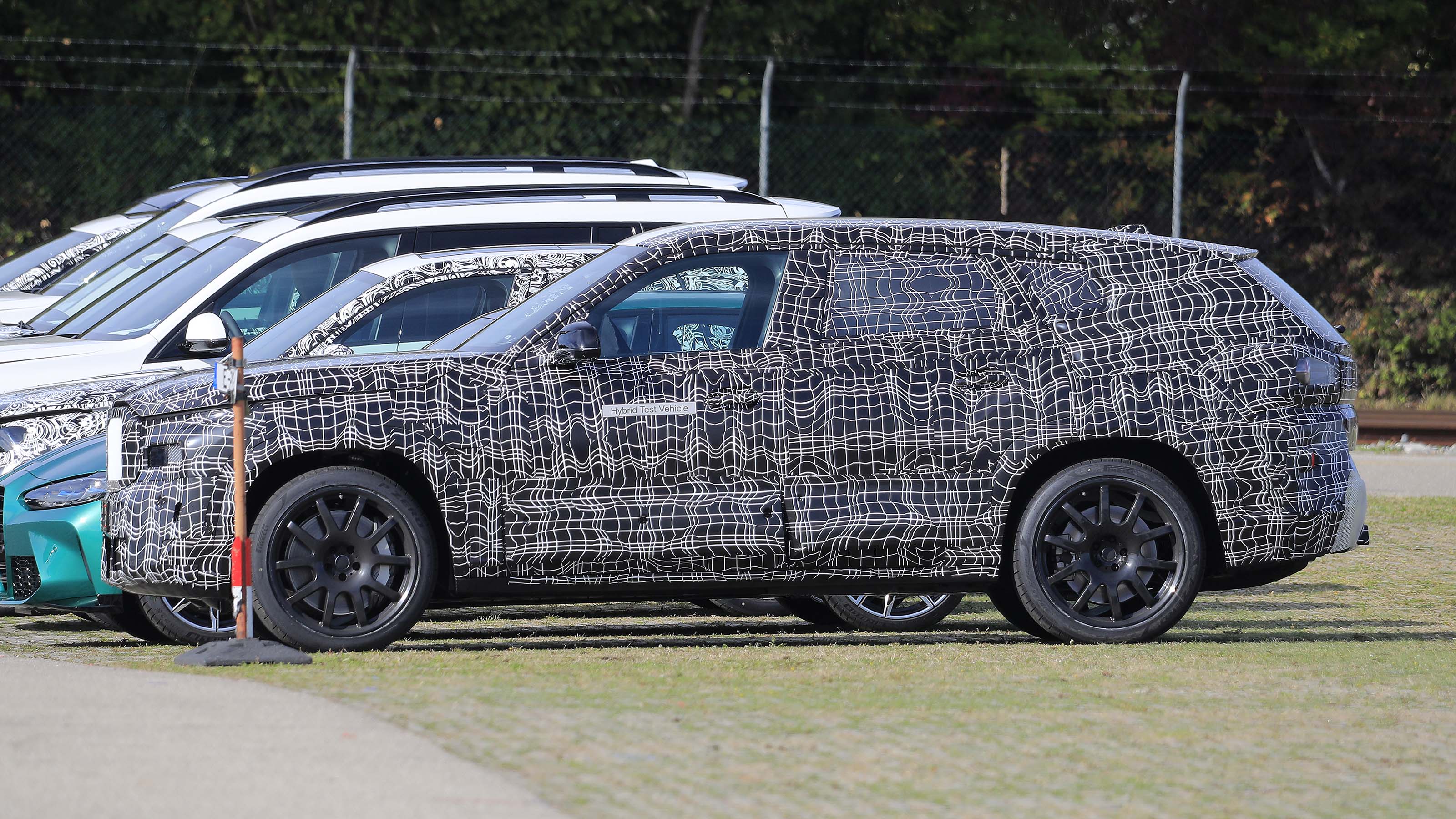 BMW X8 SUV in camouflage - side view