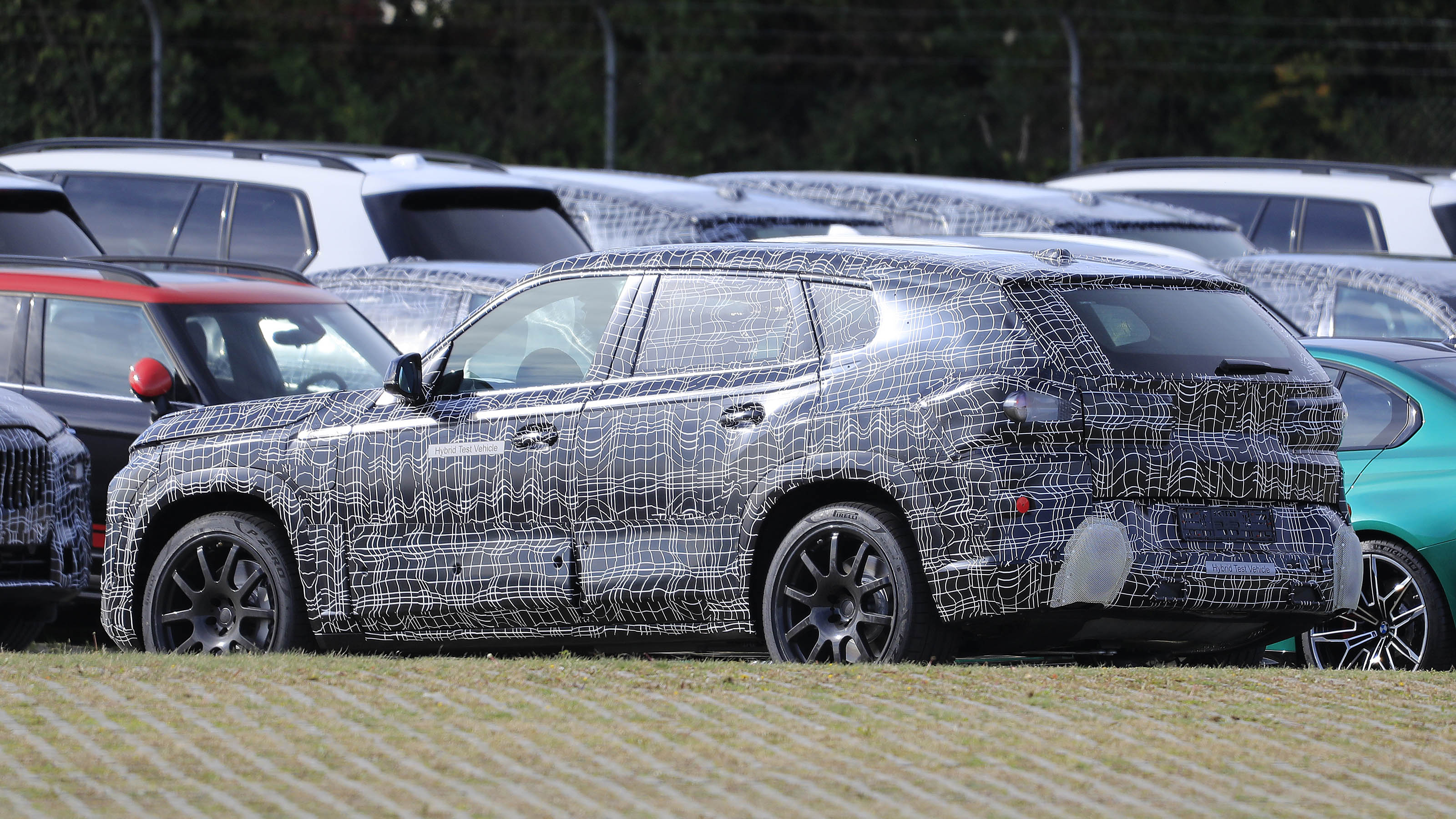 BMW X8 SUV in camouflage - side/rear view