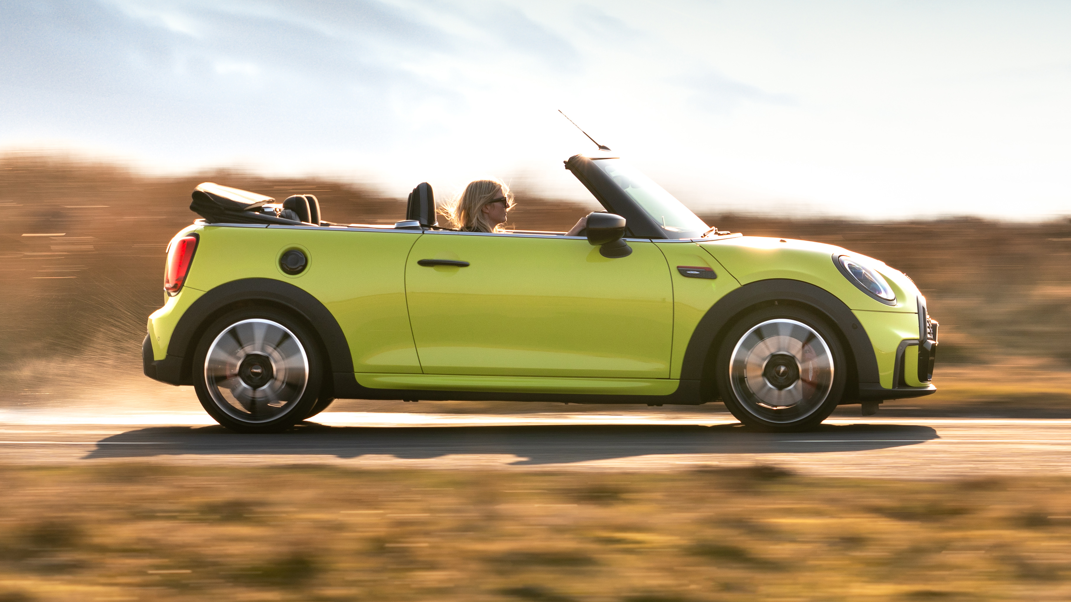 2021 MINI Convertible driving along road - side view