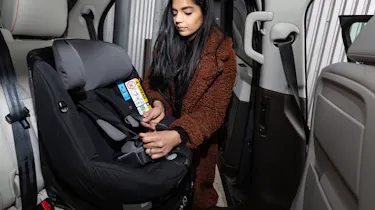 Lady putting ISOFIX child seat in car