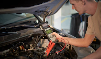 Man checking the charge of a car battery