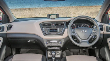 The i20's dashboard looks quite neat, but hard plastics mean parts of the interior feel cheap to the touch