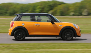 Yellow MINI driving - side view